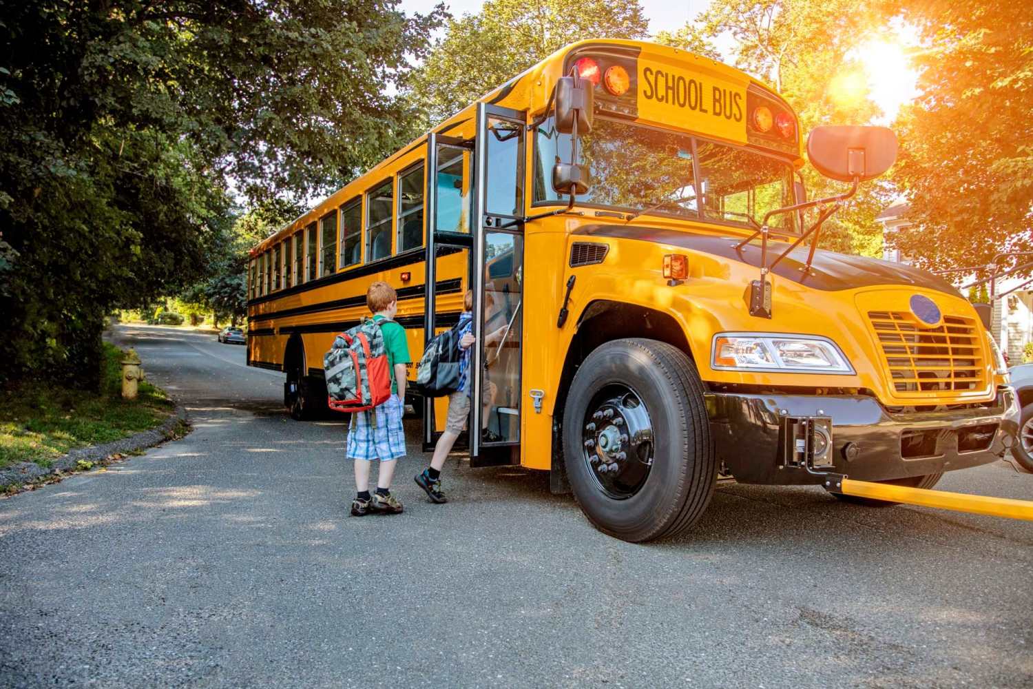 Resident children boarding their school bus joyfully near Excelsior Apartments in Brevard, North Carolina