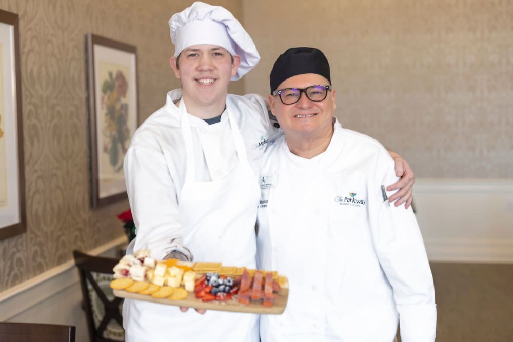 The chefs at The Madison Senior Living holding up a plate of food