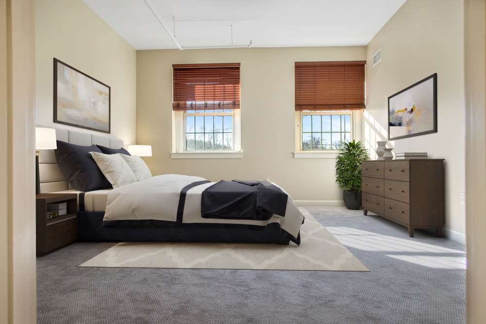 Comfortable bedroom with large bed, carpet flooring and large window at The Residences at Towne School in Acton, Massachusetts