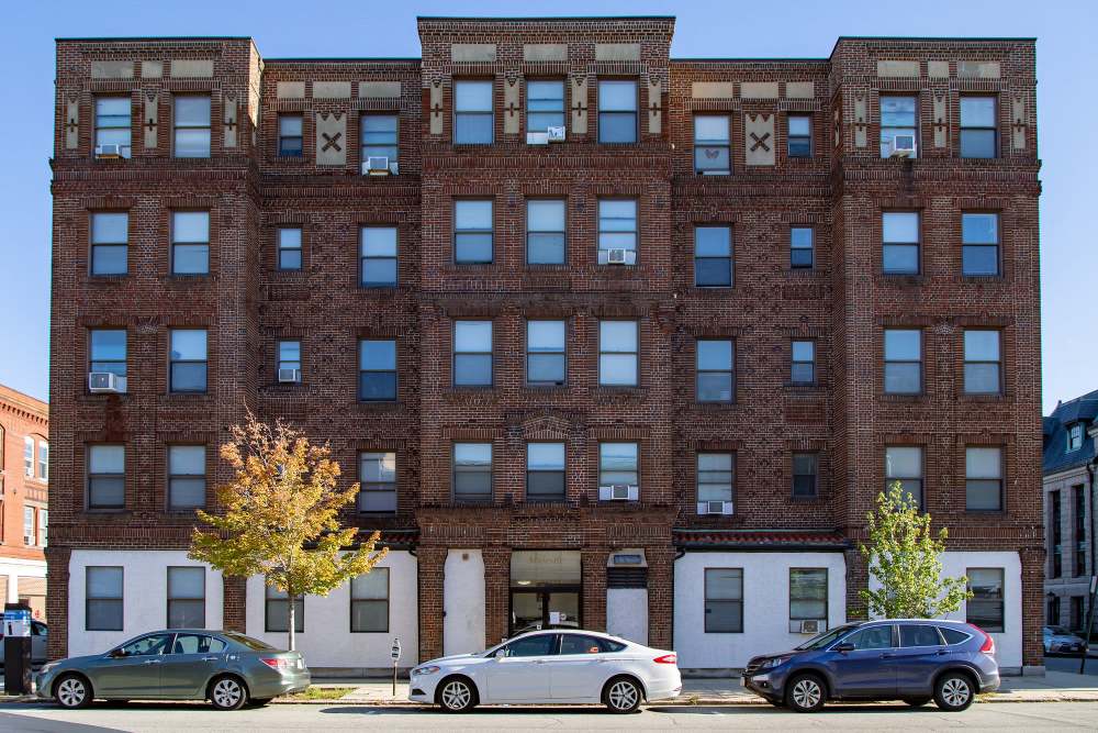 Brown brick building with multiple windows at The Majestic in Lowell, Massachusetts