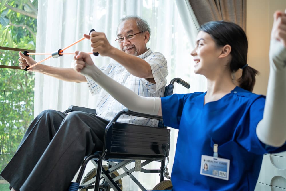 Resident with caregiver doing arm excercises Vista Prairie at Ridgeway in New Ulm, Minnesota