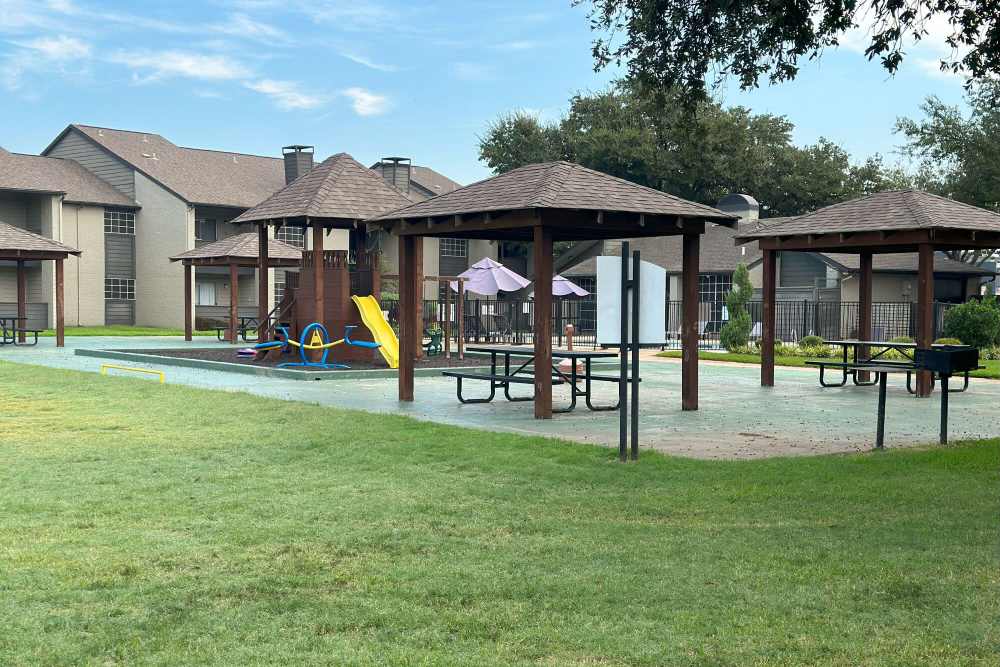 Playground and outdoor seating space with courtyard at Courts of Bedford in Bedford, Texas