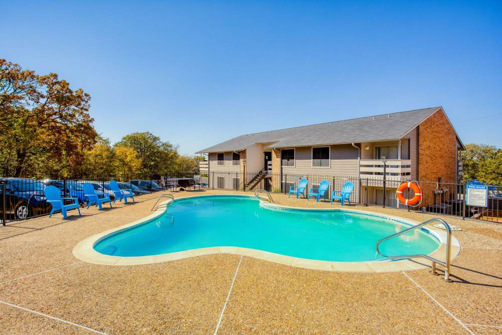 Swimming pool with seating at The Summit Apartments in Athens, Texas