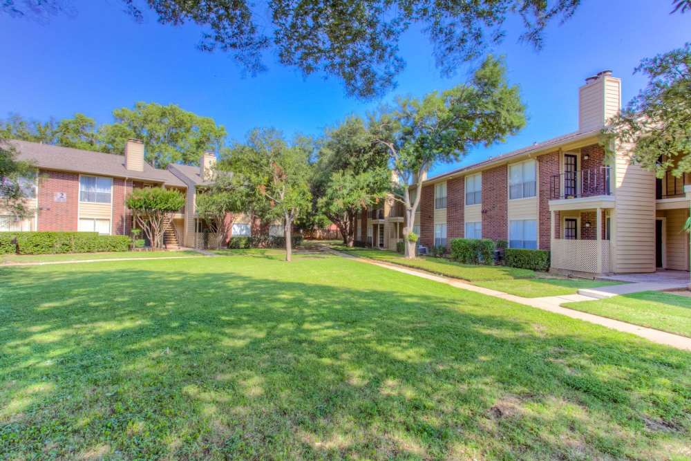 Charming apartment complex with lush landscaping and inviting green spaces at Charter Oak in Euless, Texas.