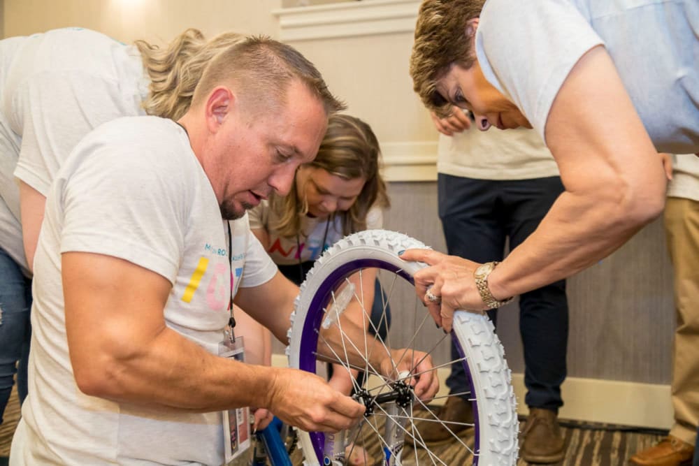 Rockers fixing a bicycle at Mission Rock Residential in Denver, Colorado