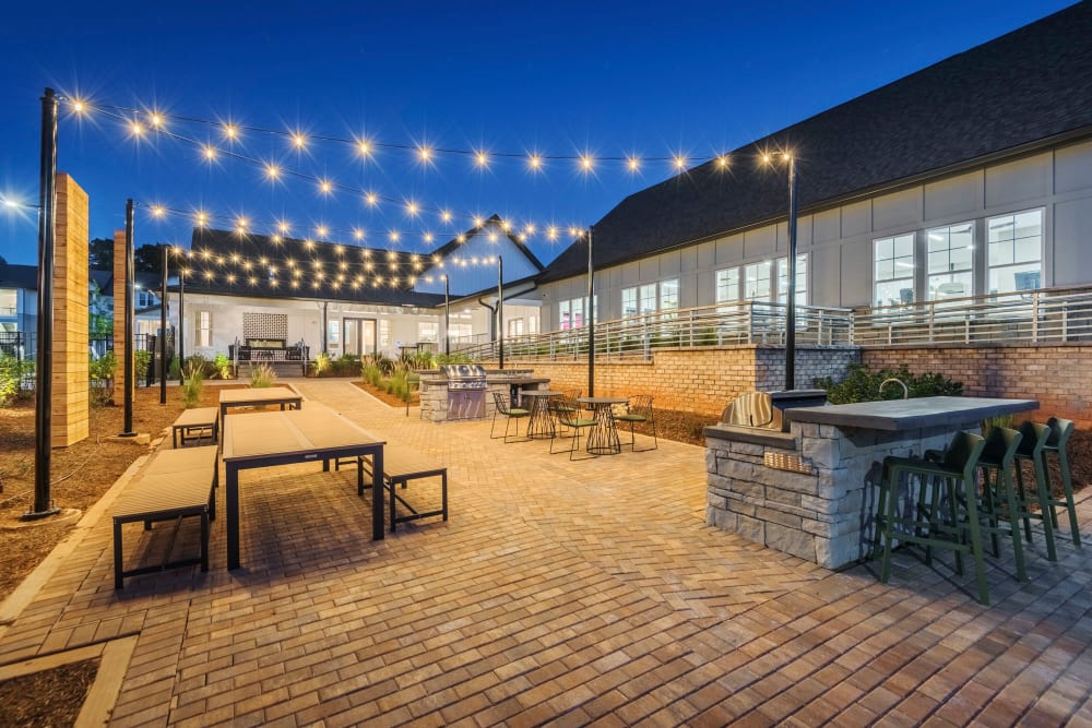 Resident grilling area at night with sparkling string lights at The Collins in Charlotte, North Carolina