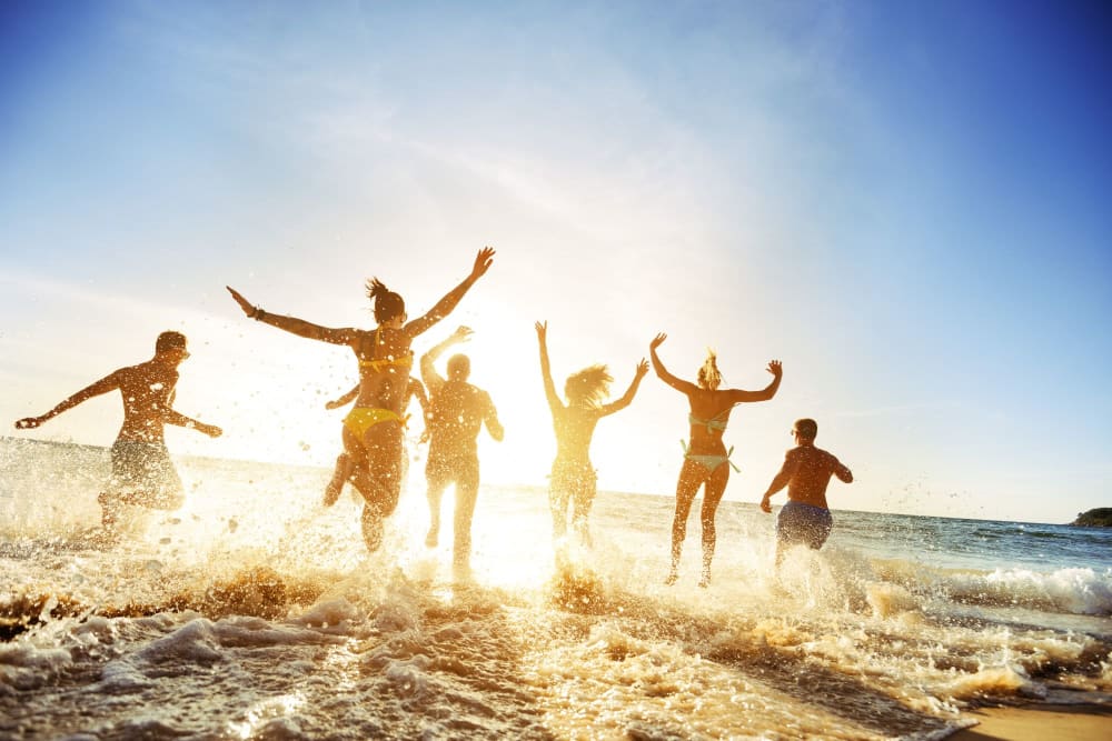 Friends jumping in the ocean near The Griffon Vero Beach in Vero Beach, Florida