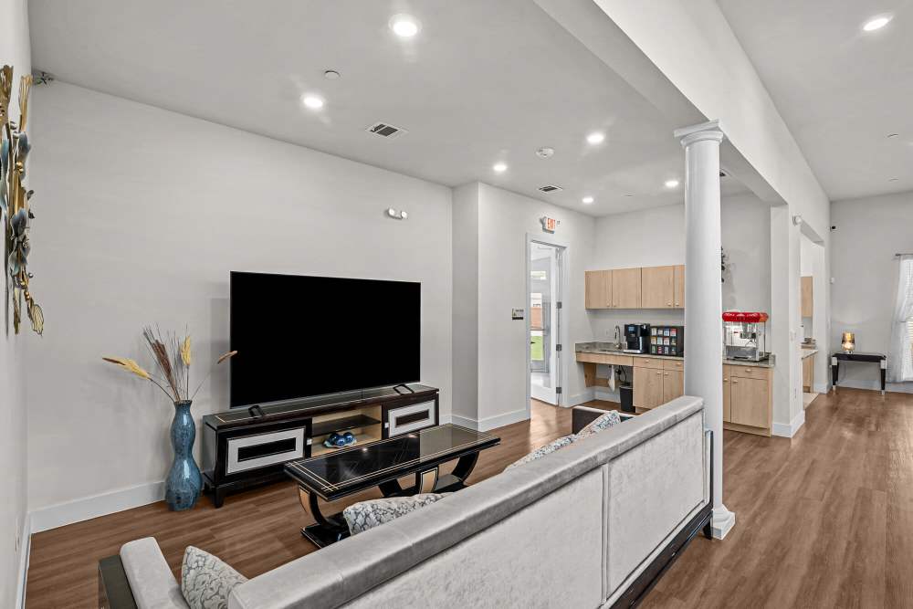 Bright community lounge with modern furniture, large windows, and wood-style flooring at Springwood at Aliana in Richmond, Texas
