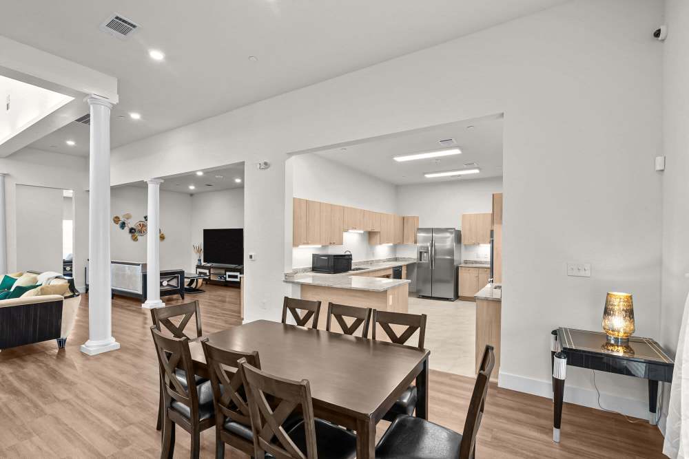 Open layout with wood-style flooring, modern kitchen featuring stainless steel appliances and granite countertops at Springwood at Aliana in Richmond, Texas
