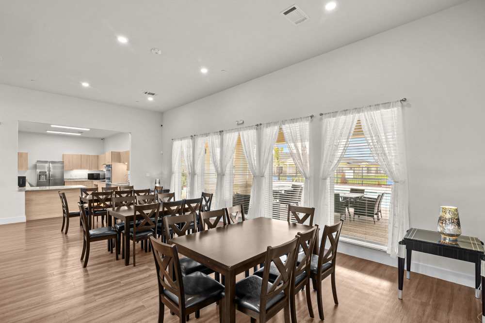 Bright community lounge with modern furniture, large windows, and wood-style flooring at Springwood at Aliana in Richmond, Texas