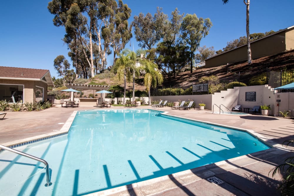Beautiful resort-style swimming pool with lounge chairs at Lakeview Village Apartments in Spring Valley, California