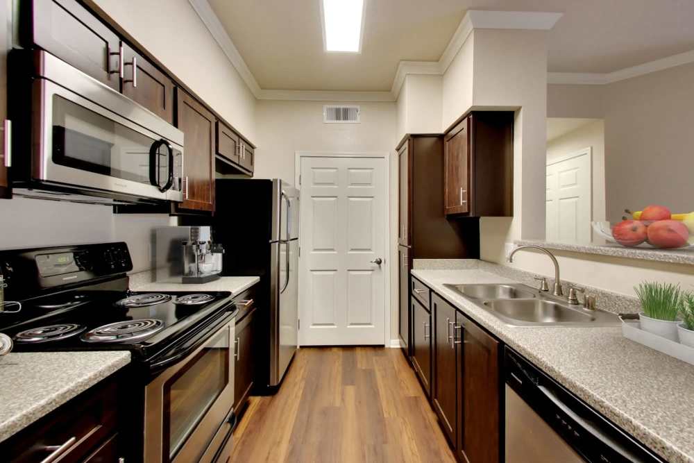 Kitchen with stainless steel appliances and espresso cabinetry at Hawthorn Village Apartments in Napa, California