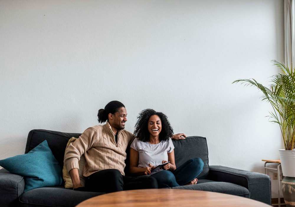 Cozy living room with a couple relaxing on the couch at Standard at Royal Lane in Dallas, Texas