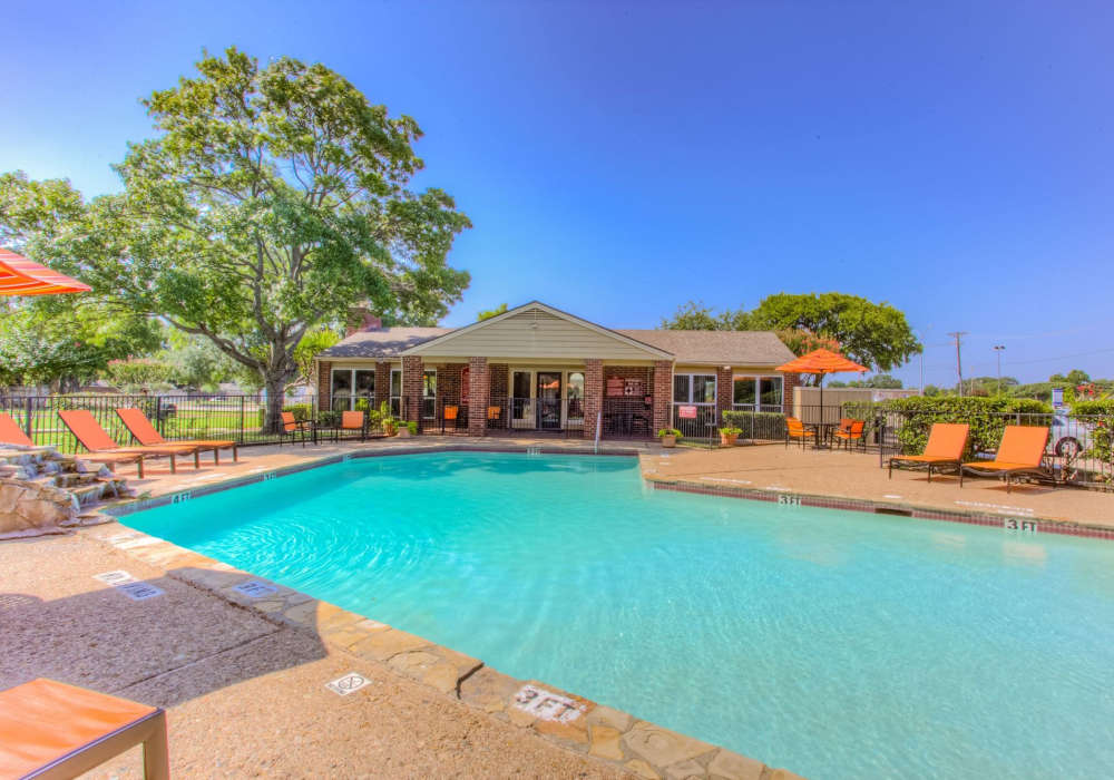 Charming outdoor oasis with a sparkling water pool and inviting lounge area at Charter Oak in Euless, Texas.