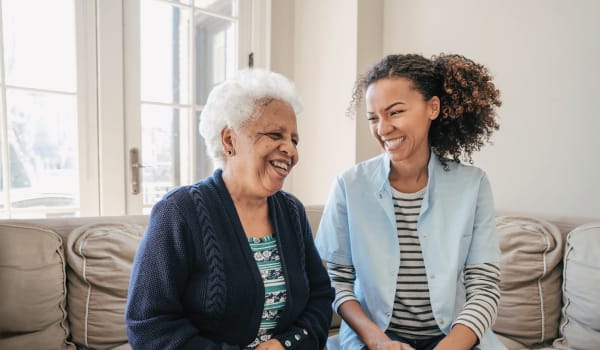 Resident sitting with a younger person talking at a Anthology Senior Living community