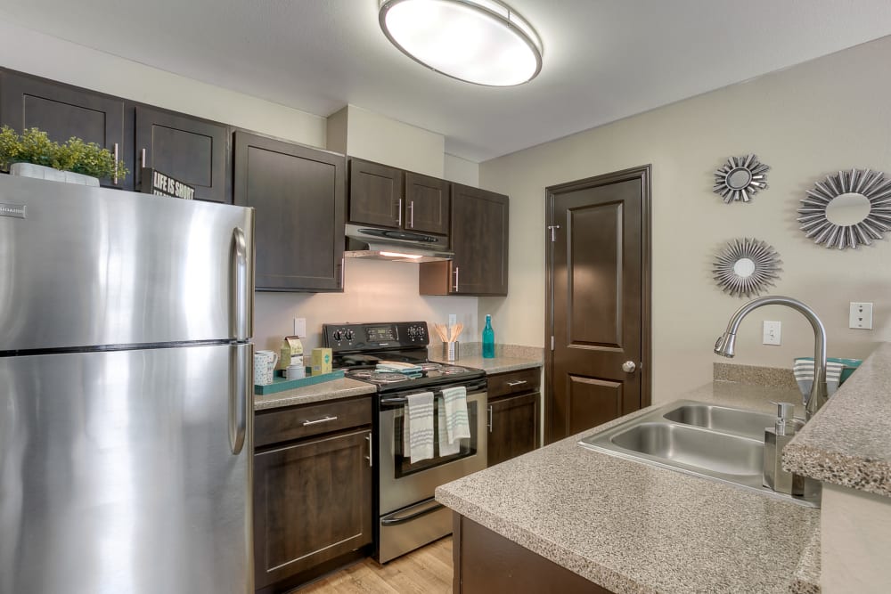 A kitchen complete with modern espresso cabinetry at Pebble Cove Apartments in Renton, Washington