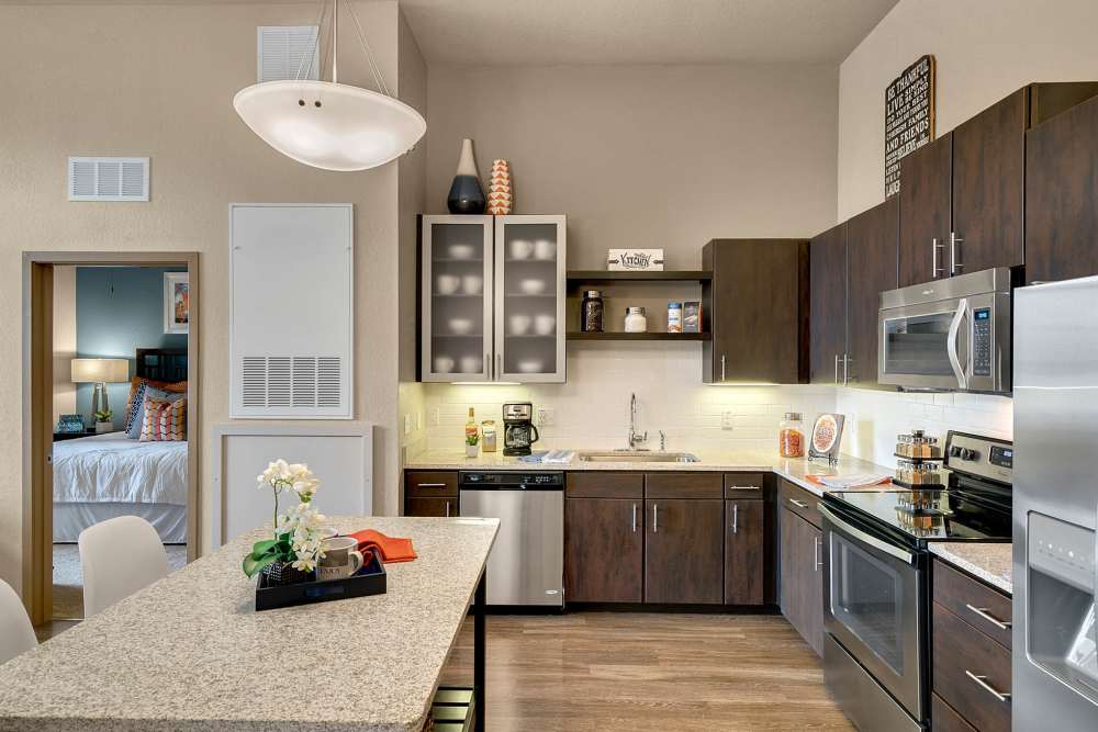 Apartment kitchen with dining table and dark wood cabinets at Station House at Lake Mary in Lake Mary, Florida