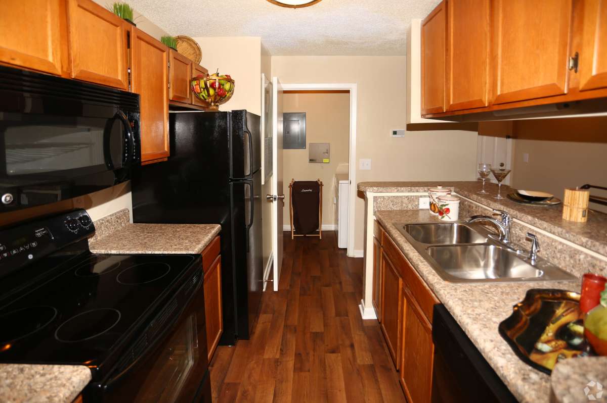 Open kitchen with black appliances and granite countertop at Avenue at Harbison in Columbia, South Carolina