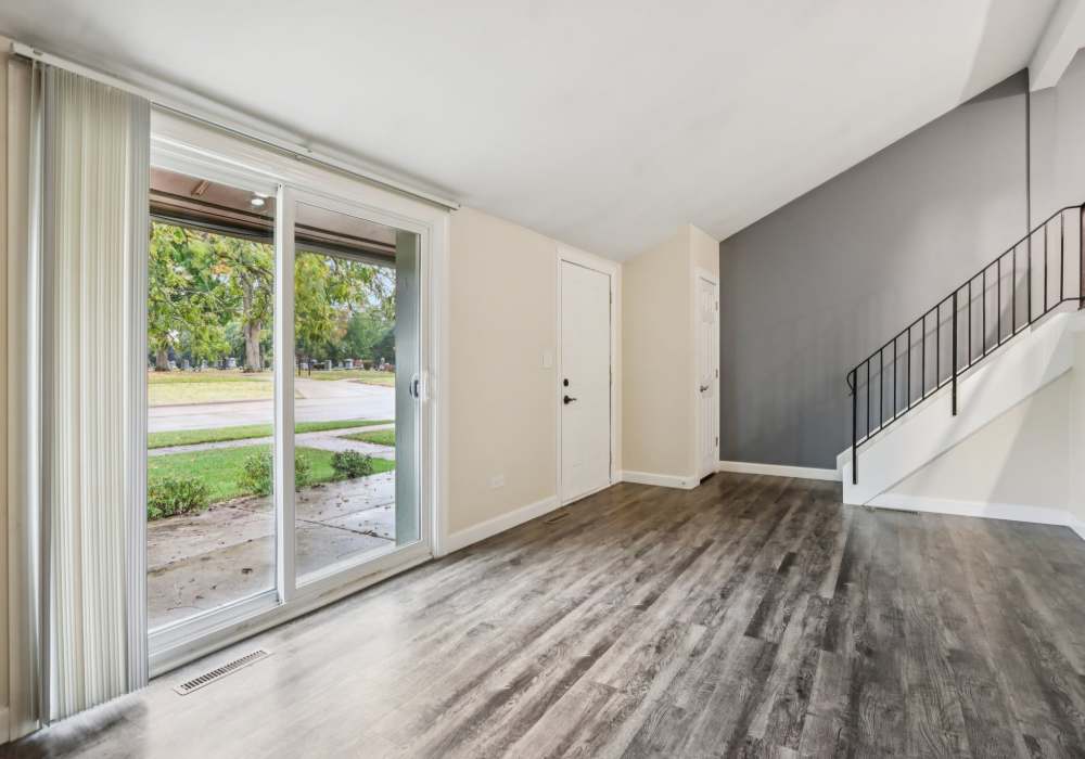 Unfurnished living room having wood floor with access balcony at Crystal Lake Apartments in Crystal Lake, Illinois