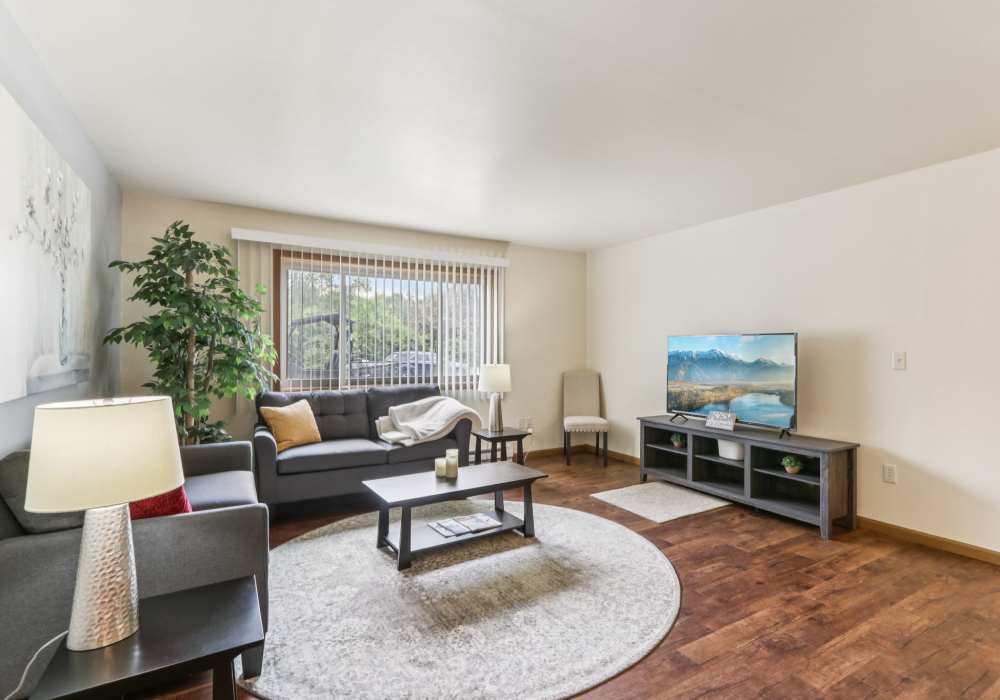 Living room with wooden flooring at Woodfield Heights Apartments in Waukesha, Wisconsin