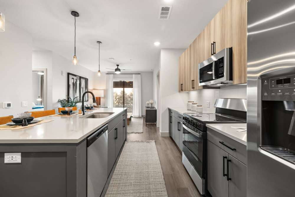 Granite countertops and custom wood cabinetry in a model home's kitchen at The Lock at Flatirons in Broomfield, Colorado