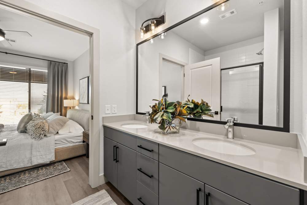Bedroom with attached bathroom in a model apartment at The Lock at Flatirons in Broomfield, Colorado