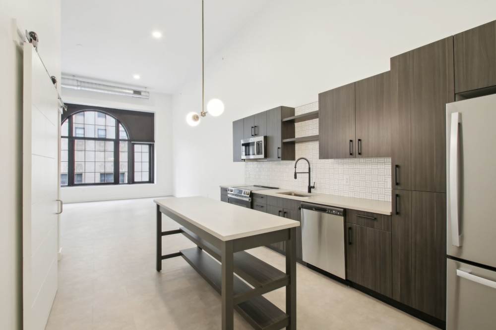 Model apartment kitchen with wooden cabinets at The Edmond in Rochester, New York