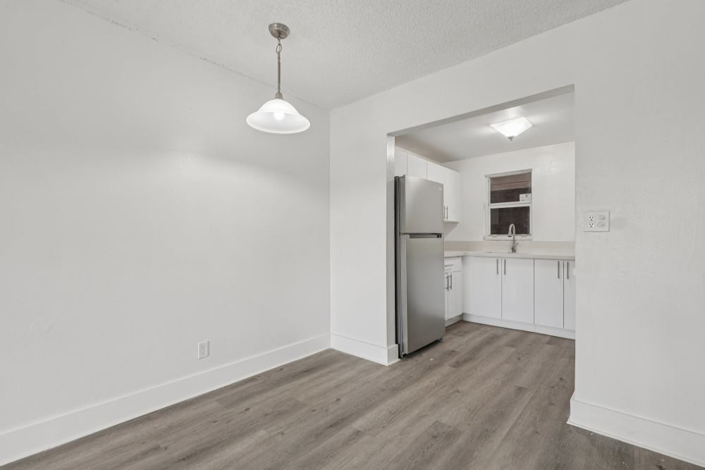 Refrigerator and kitchen sink with granite countertops at El Jardin Apartments in Hollywood, Florida
