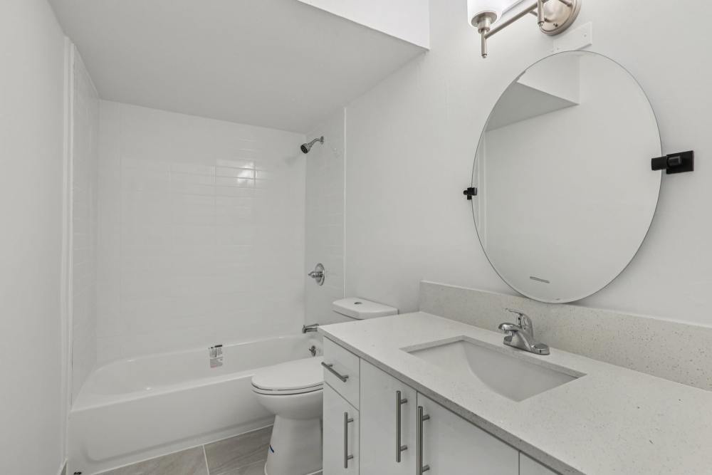 Apartment bathroom with stylish vanity mirror at El Jardin Apartments in Hollywood, Florida