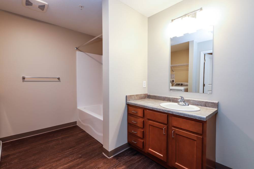 Spacious bathroom with wood-style flooring, vanity, and bathtub with shower combination at Keyser Greene in Keyser, West Virginia