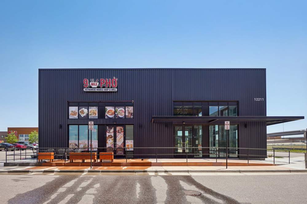 Exterior of 9 Mile PHỞ restaurant with food images and signage at Tempo at Nine Mile Station in Aurora, Colorado