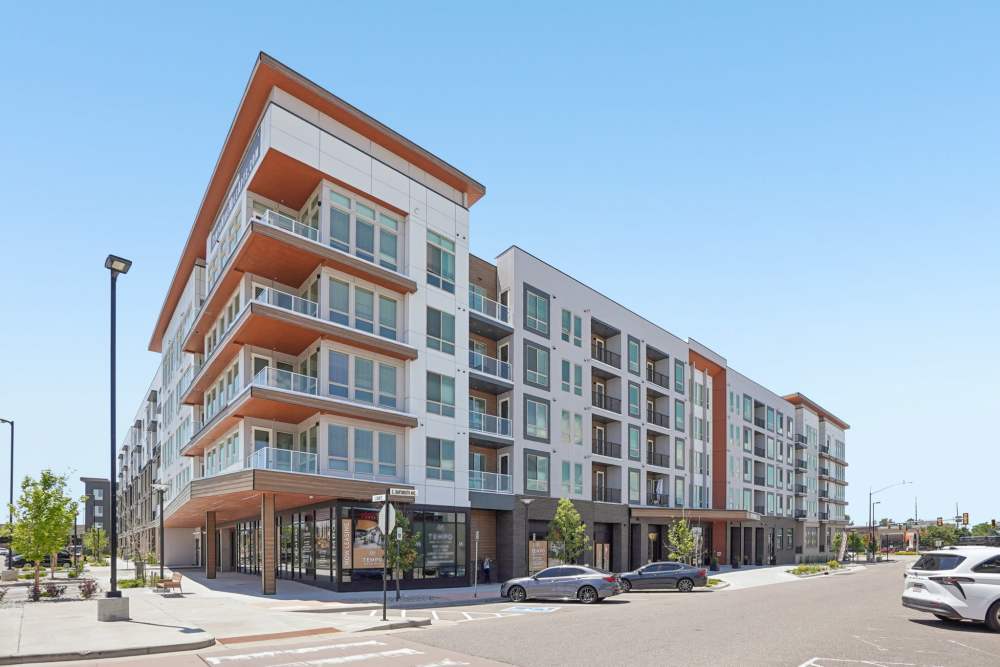Modern apartment building with balconies and street parking at Tempo at Nine Mile Station in Aurora, Colorado
