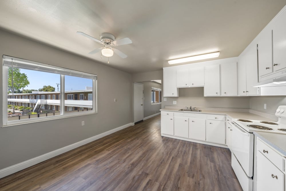 Kitchen with large window at Garden Court Apartments in Alameda, California