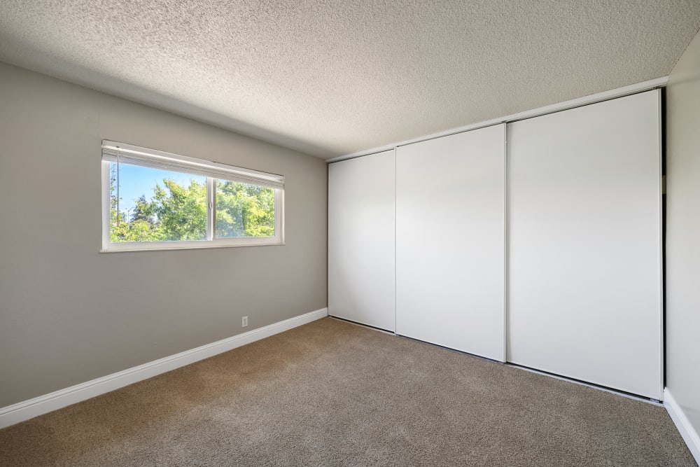 Comfortable bedroom with spacious closet and plush carpeting at Garden Court Apartments in Alameda, California