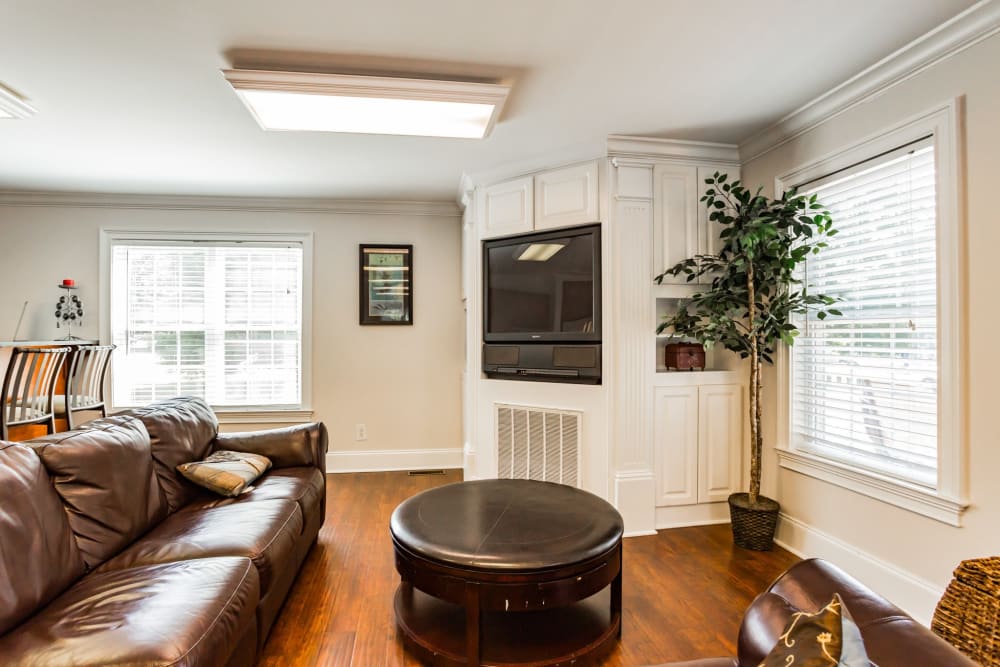 Lounge area with a fireplace and a wall mounted tv at The Fairways Apartments and Townhomes in Thorndale, Pennsylvania