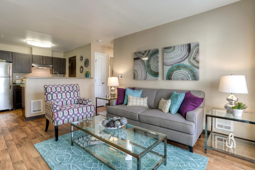 Living room with wood-style flooring at Pebble Cove Apartments in Renton, Washington