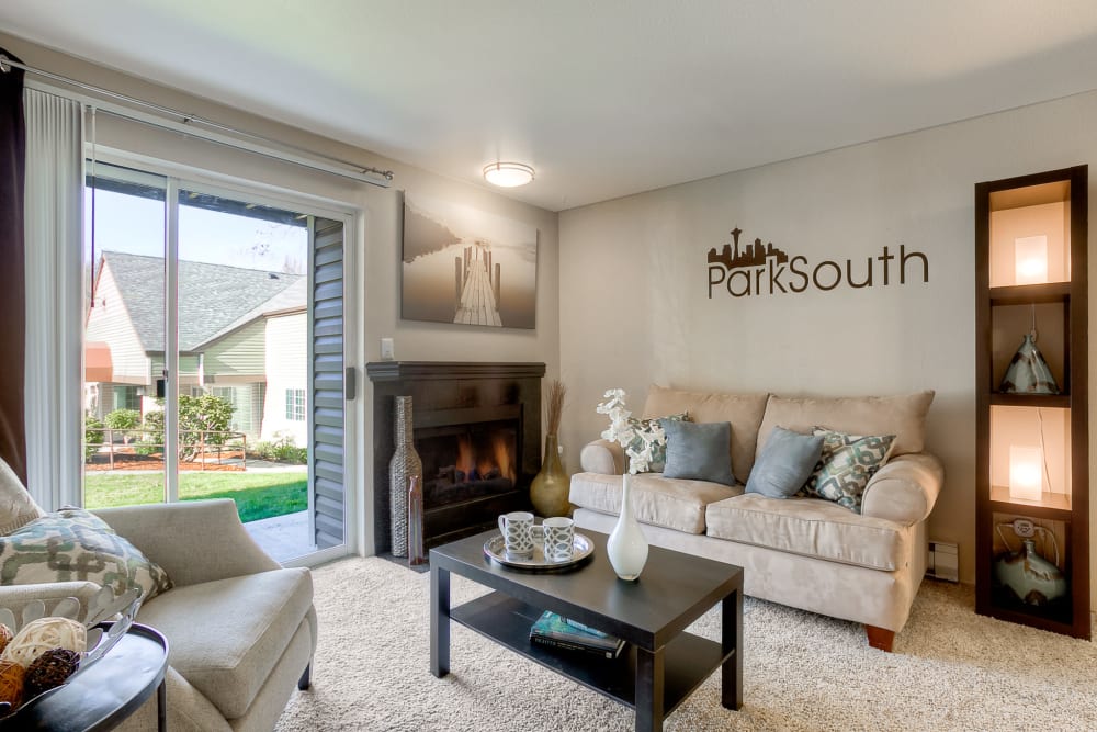 Sunny and spacious living room with a fireplace at Park South Apartments in Seattle, Washington