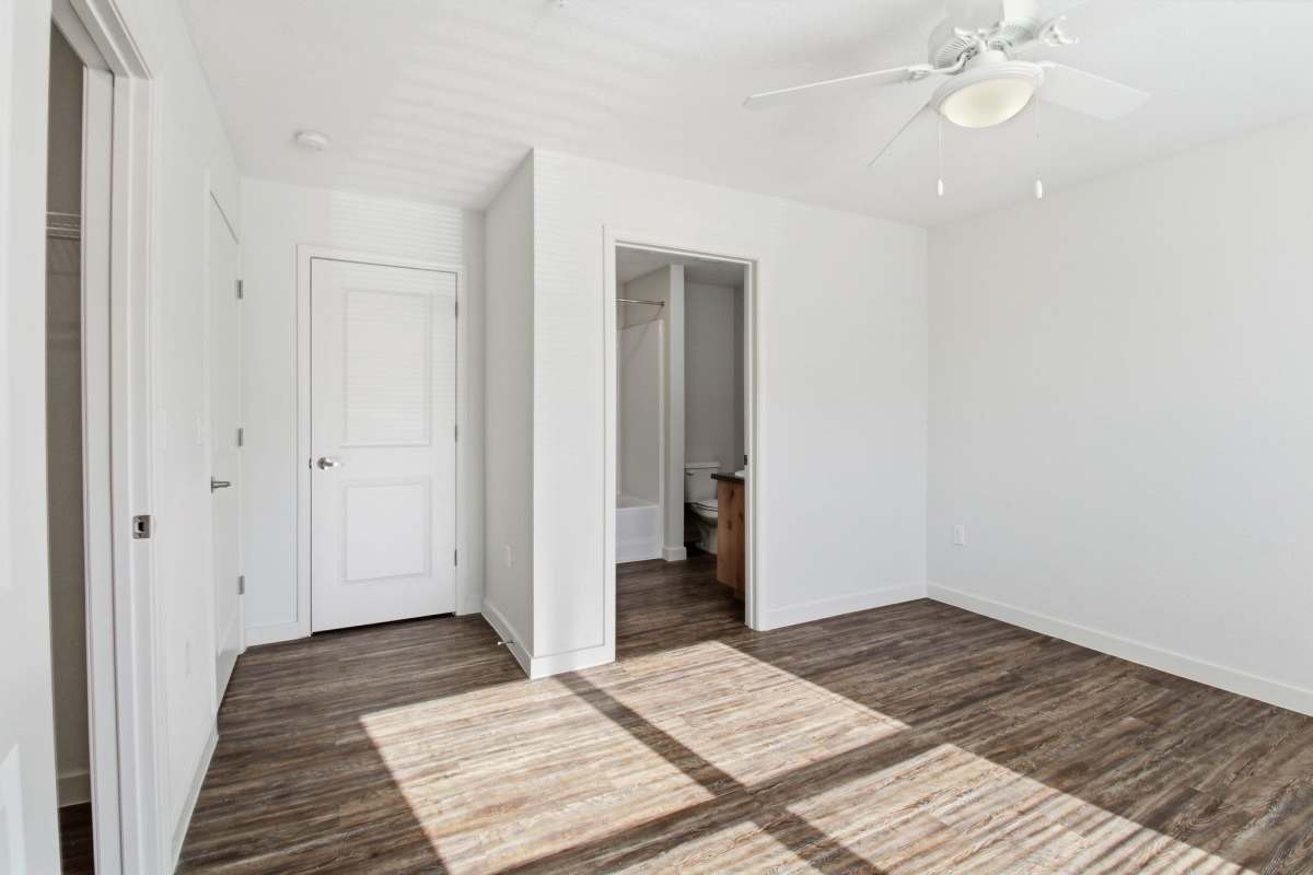 Unfurnished bedroom with ceiling fan and attached bathroom at Butler Park in Andrews, Texas 