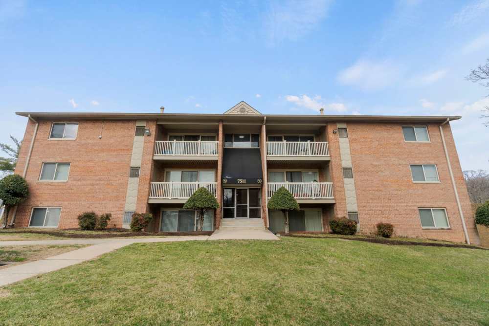 Front shot of the apartments with beautiful landscaped ground at Chesapeake Landing Apartments in Landover Hills, Maryland