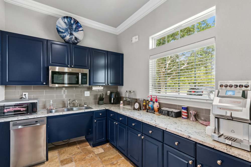 Clubhouse prep kitchen featuring stainless steel dishwasher, microwave, toaster oven, and coffee station at Residence at Lake Jackson in Lake Jackson, Texas