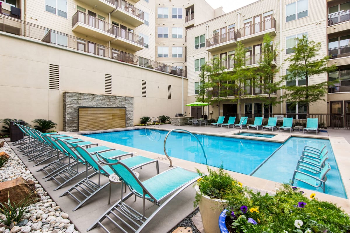 Luxe swimming pool with lounge chairs on deck at The Marq on West 7th in Fort Worth, Texas