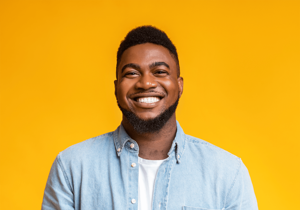 Resident smiling for a great photo with a bright yellow background at BB Living in Scottsdale, Arizona