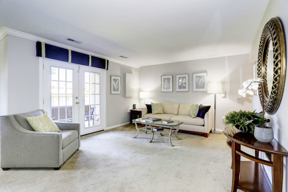 Model living room with doors to balcony at Tuscany Gardens in Windsor Mill, Maryland