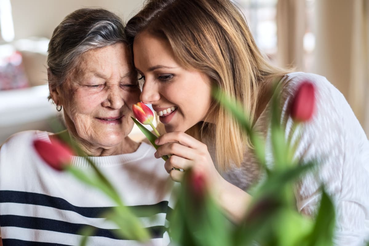 Mother and daughter smelling flowers at Canoe Brook Assisted Living in Wichita, Kansas