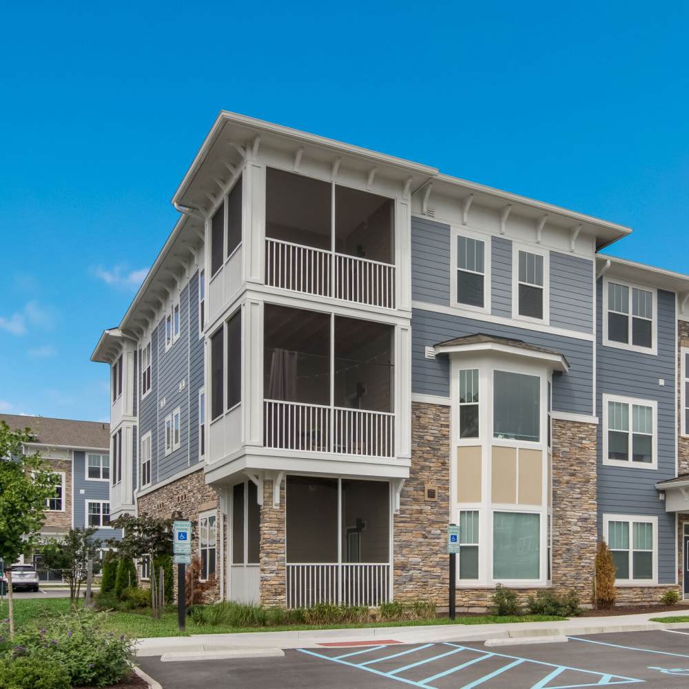 Modern apartment with screened balcony and stone accents at The Apartments At Kelton Station in Williamsburg, Virginia