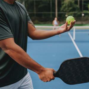 Resident ready to serve on a vibrant pickleball court at Pomona Apartments in Ocala, Florida
