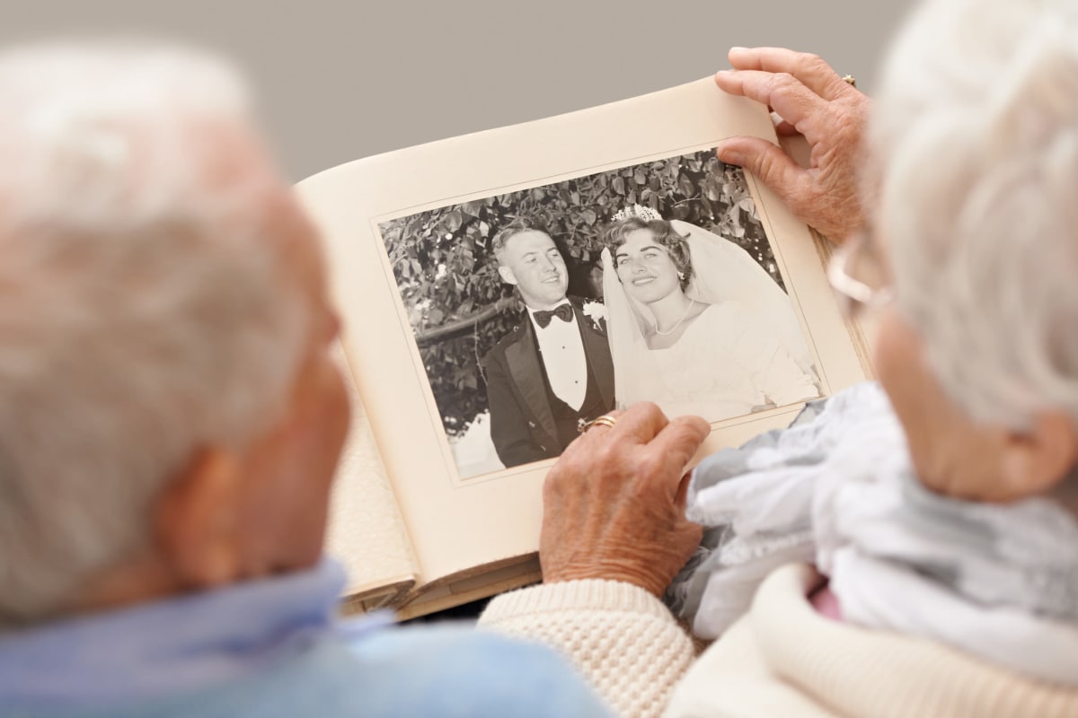 Resident couple looking through a photo album at Riverside Oxford Memory Care in Ft. Worth, Texas