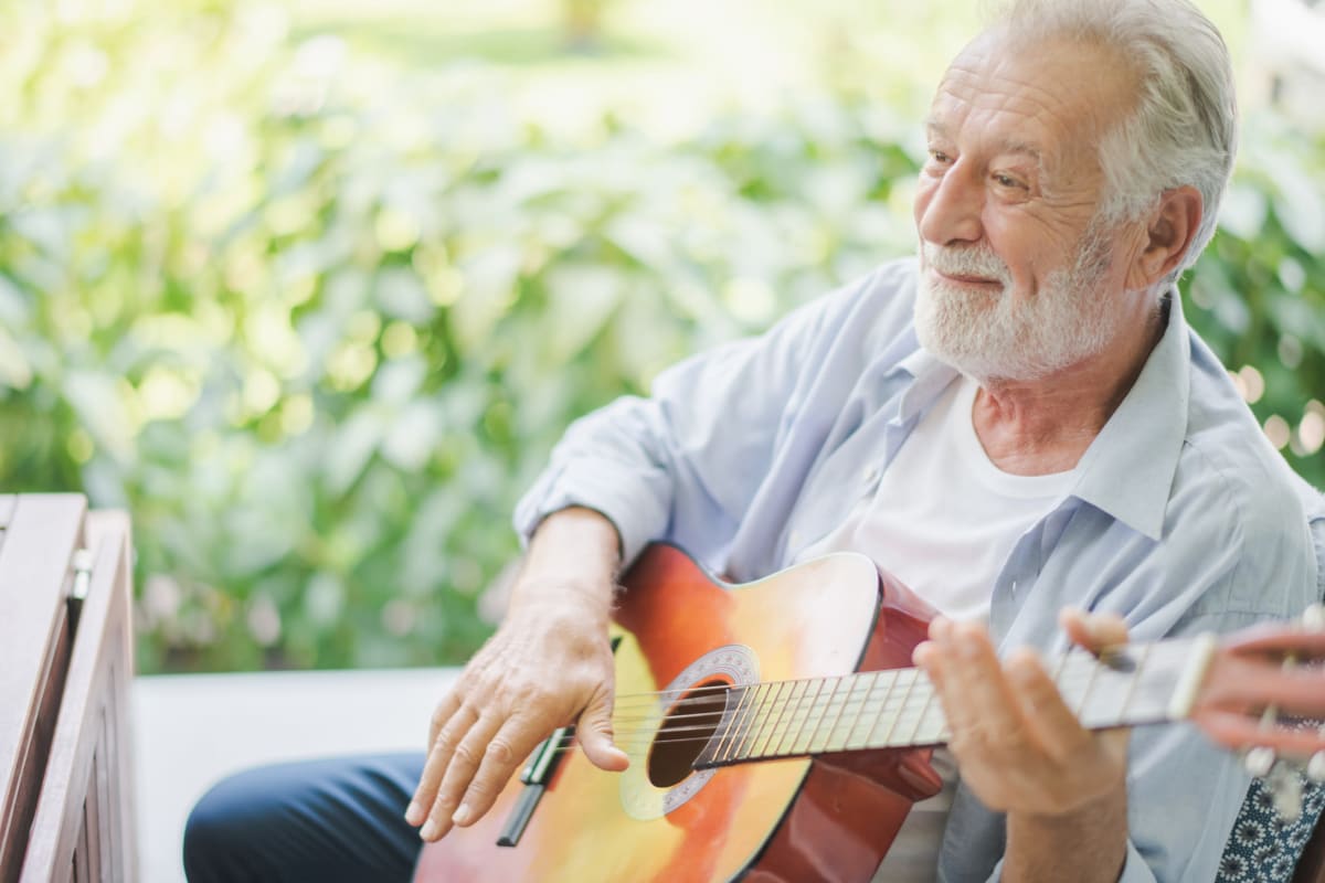 Resident playing the guitar at The Oxford Grand Assisted Living & Memory Care in Kansas City, Missouri