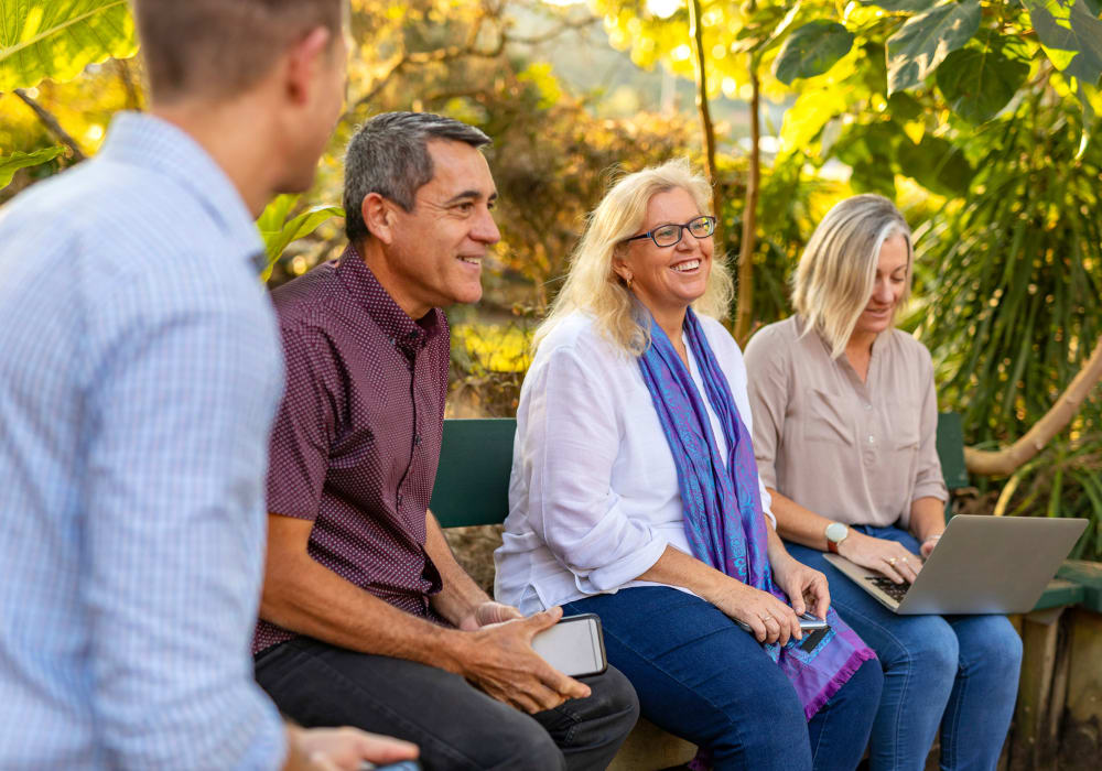 Resident and their family sitting outdoors at Carriage Inn Huntsville in Huntsville, Texas.