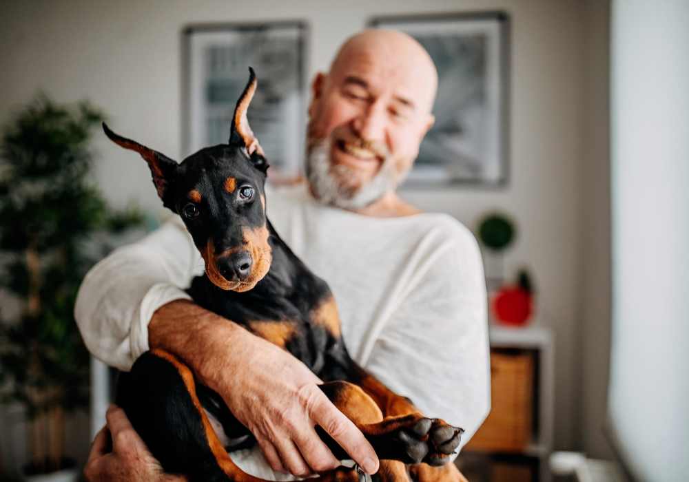 Resident hugging his dog in their pet-friendly home at Terrace at Southern Oaks in Dallas, Texas